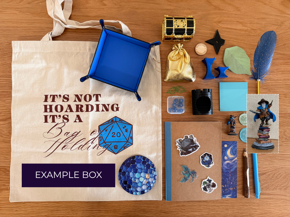 Leviathan's Trove Mystery Box contents arranged on a wooden tabletop, including a small gold-and-black treasure chest, crystals, a dark metallic figurine, dice, a notebook, rods, a velvet pouch, and a central purple banner reading 'LEVIATHAN'S TROVE MYSTERY BOX'.